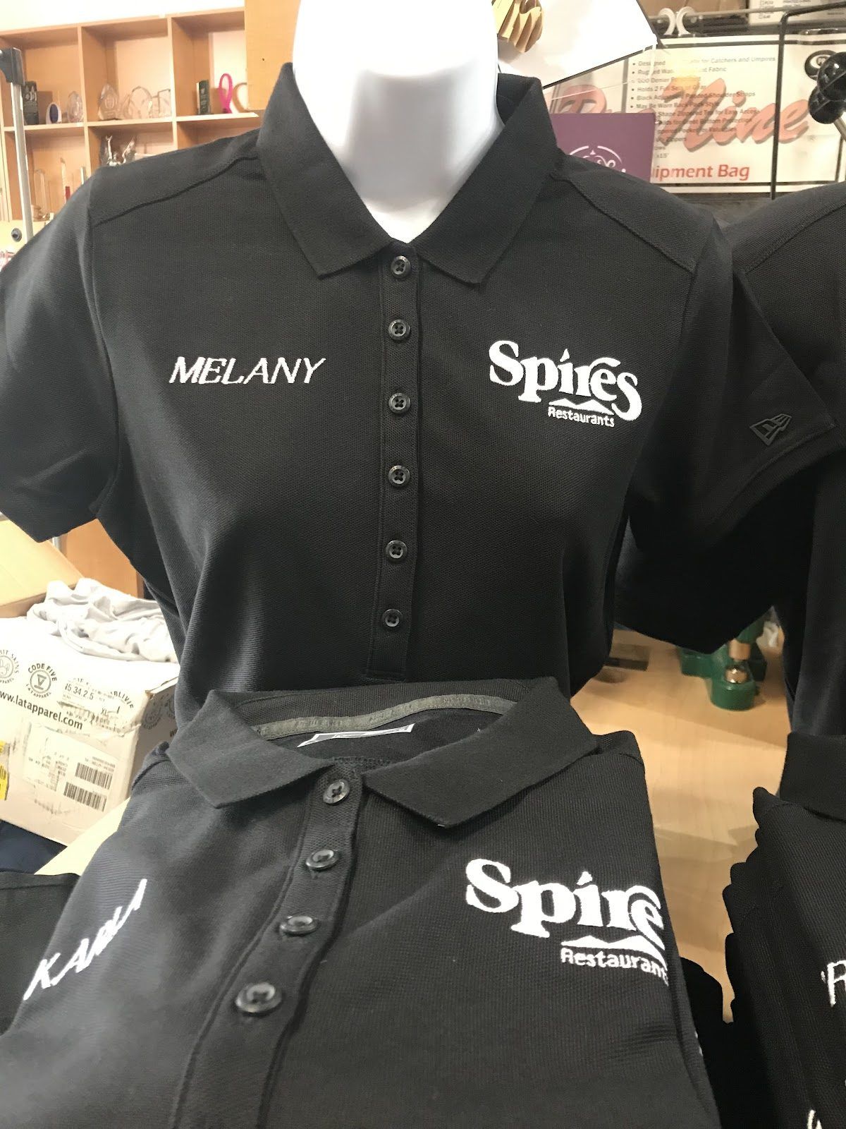 Black polos embroidered with a restaurant’s logo on one side of the chest and each server’s name on the other