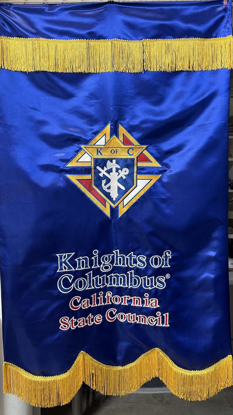 A royal blue satin banner with gold fringe, the Knights of Columbus emblem and the words Knights of Columbus California State Council