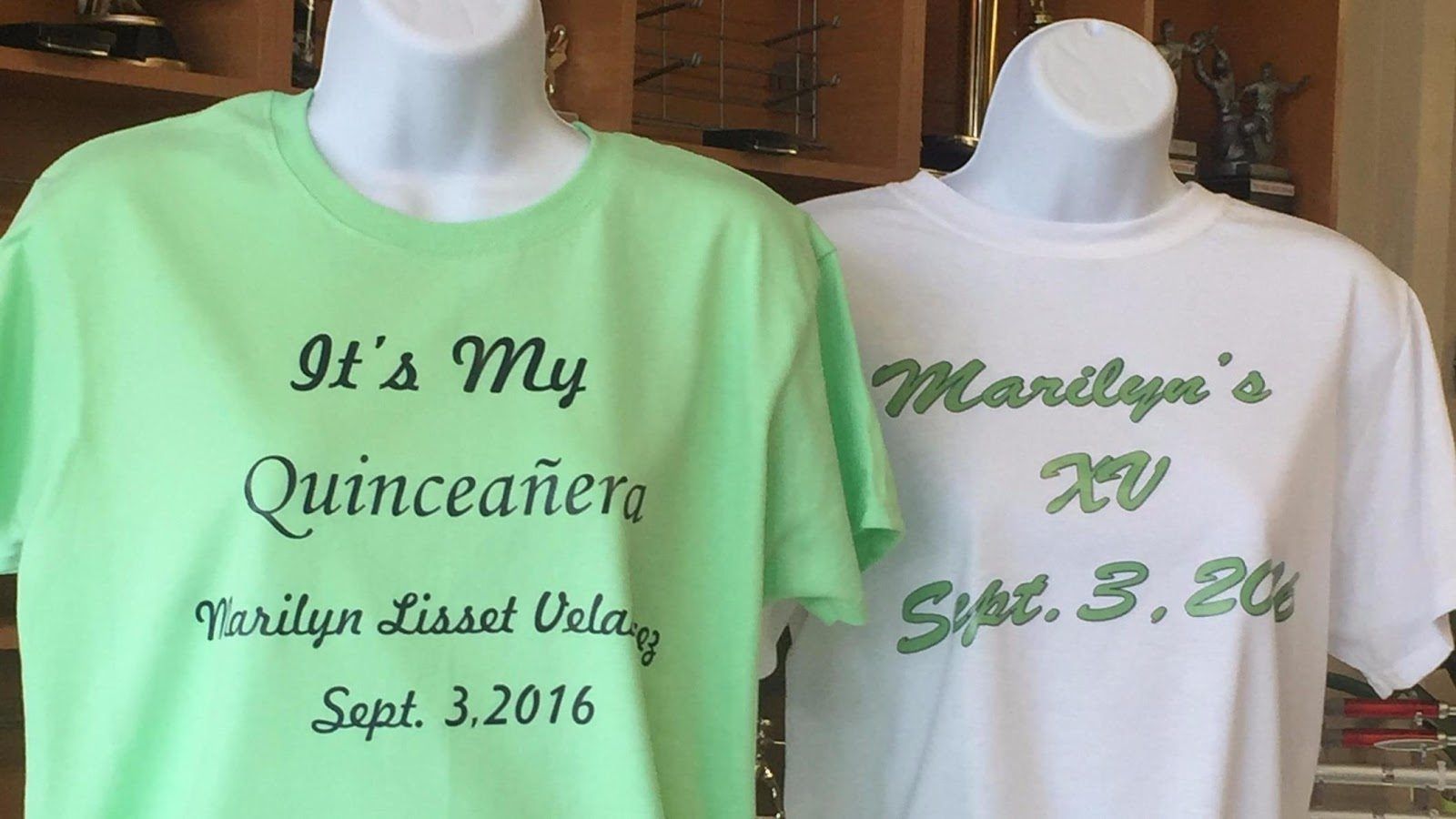 A mint green tee printed It’s My Quinceañera with a name and date, next to a white tee printed with her name, XV and the date in green script