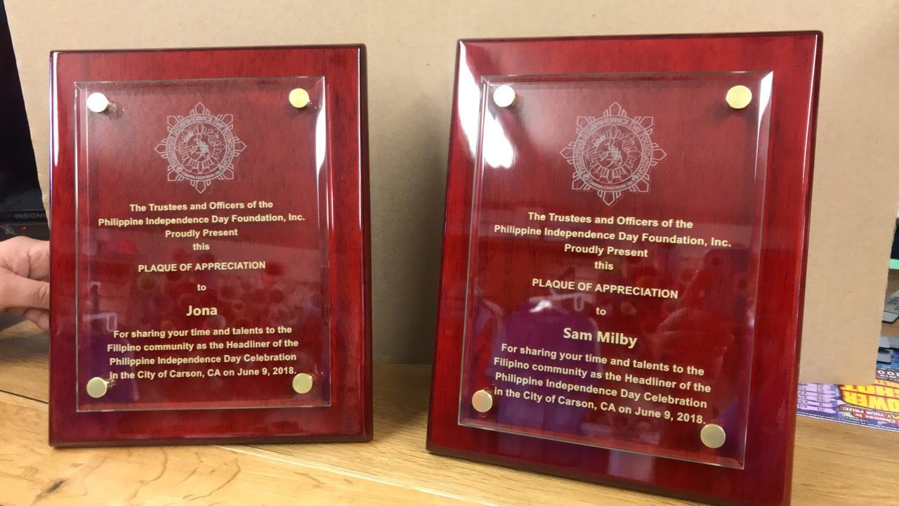 Two red piano-finish plaques with engraved glass plates, thanking the headliners of Carson’s 2018 Philippine Independence Day Celebration